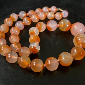 Victorian necklace of knotted, graduated agate, carnelain beads in luminous sunrise colors .