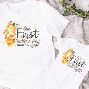 May include: Two white t-shirts with a fox graphic and the text "Our First Father's Day Jayden & Daddy 2021".