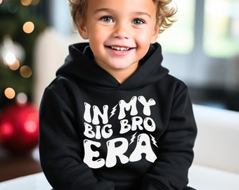 May include: A black hooded sweatshirt with white text that reads "In My Big Bro Era" with a lightning bolt graphic.