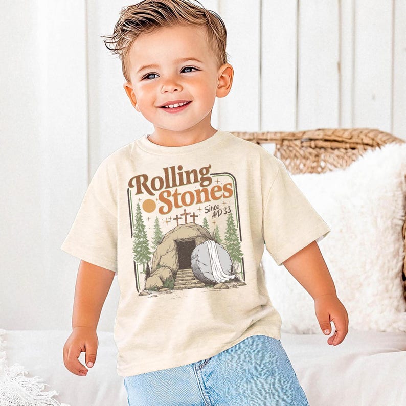 toddler boy wearing easter christian shirt with rolling stones on the front and the empty tomb of jesus