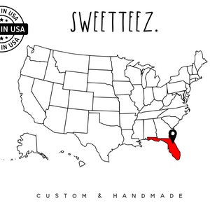 May include: A map of the United States with Florida highlighted in red, marked with a black location pin. The text "SWEETTEEZ" is above the map. The words "MADE IN USA" are in a circular stamp. The text "CUSTOM & HANDMADE" is below the map.