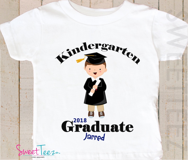 May include: White t-shirt with a black graphic of a boy wearing a graduation cap and gown holding a diploma. The text "Kindergarten Graduate 2018" is above the boy and the name "Jarred" is below the boy.