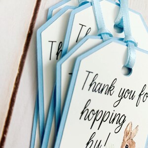 Peter Rabbit "Thank you for hopping by" birthday or baby shower party favor tags. The color of Peter Rabbit's jacket is customizable and can be changed from blue to pink, green or yellow. The background and ribbon will coordinate with Peter Rabbit's Jacket. The text is also customizable.