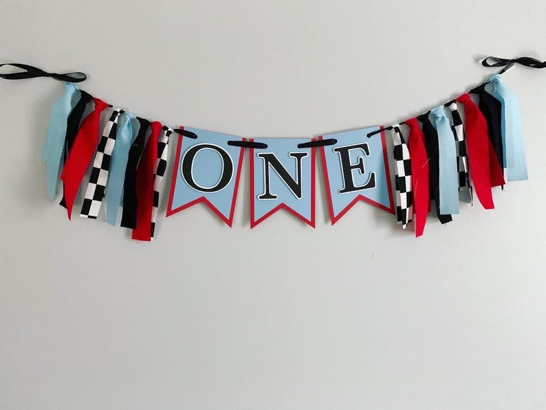 red blue and black racing themed high chair one banner featuring checkered flag fabric