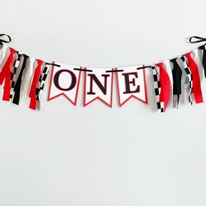 red, white and black racing themed high chair one banner featuring checkered flag fabric