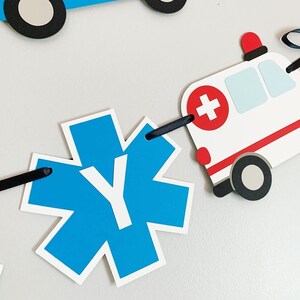 first responders emergency vehicle happy birthday banner featuring police car and badges, EMT ambulance and emblem, firetruck and fire emblem