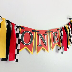 red yellow and black racing themed high chair one banner featuring checkered flag fabric