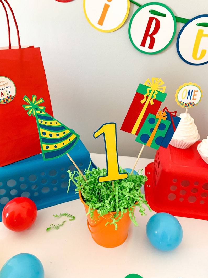 primary colors birthday centerpiece table decor that includes a party hat, number and birthday gifts made of layered cardstock
