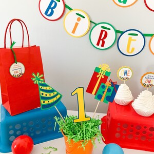 primary colors birthday centerpiece table decor that includes a party hat, number and birthday gifts made of layered cardstock