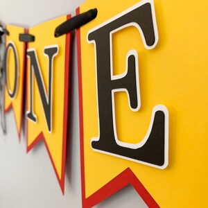 red yellow and black racing themed high chair one banner featuring checkered flag fabric