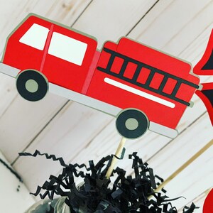 firefighter centerpiece birthday decorations featuring a firetruck, emblem with age, flame, fire hydrant, dalmatian and fire extinguisher