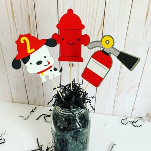firefighter centerpiece birthday decorations featuring a firetruck, emblem with age, flame, fire hydrant, dalmatian and fire extinguisher