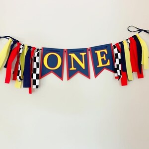 red yellow and navy blue racing themed high chair one banner featuring checkered flag fabric