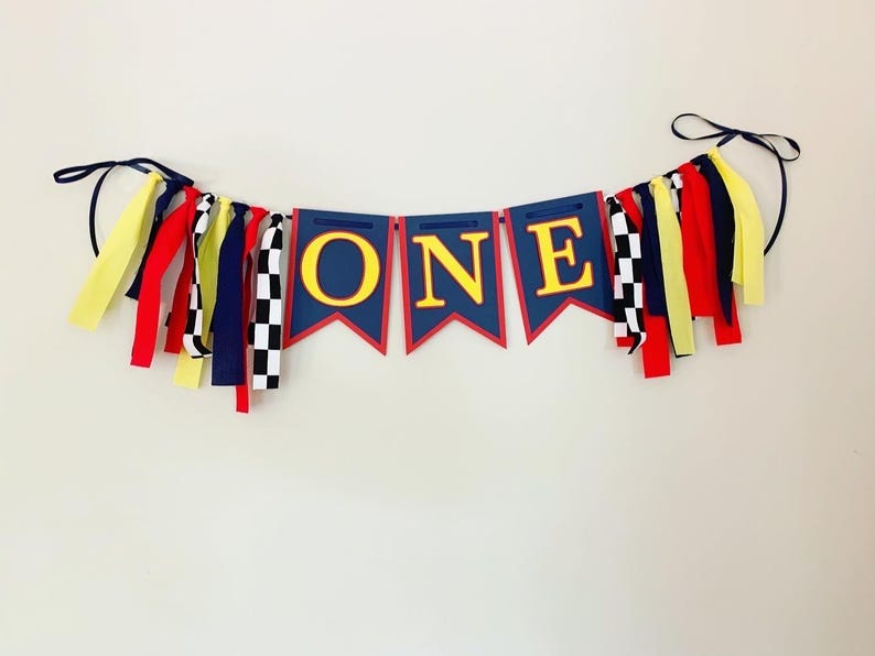 red yellow and navy blue racing themed high chair one banner featuring checkered flag fabric