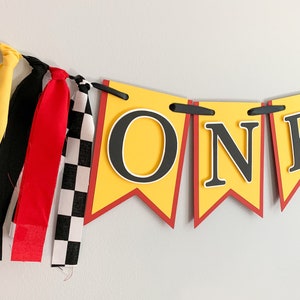 red yellow and black racing themed high chair one banner featuring checkered flag fabric