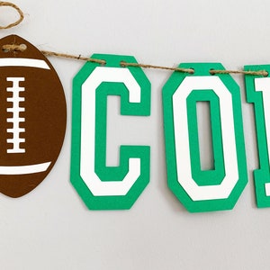 football concessions banner featuring varsity letters and two footballs that will be perfect for your little one's football themed birthday party, super bowl game day party, sports team party or to hang on your schools concession stand during football season. The banner is fully customizable.