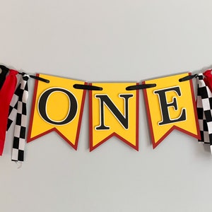 red yellow and black racing themed high chair one banner featuring checkered flag fabric