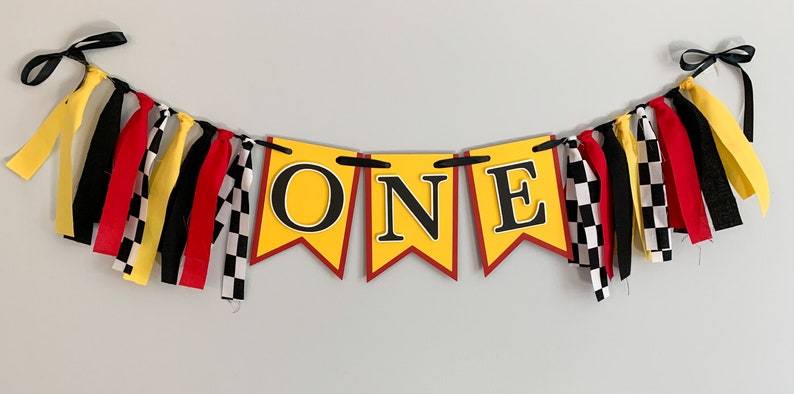 red yellow and black racing themed high chair one banner featuring checkered flag fabric