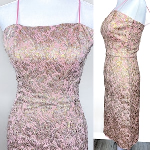 May include: A pink and gold brocade dress with a strapless neckline and a fitted silhouette. The dress features a subtle floral pattern and a delicate sheen.