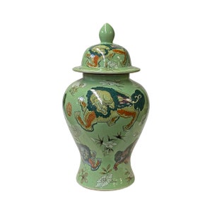 Peut inclure: Un vase en céramique vert avec un couvercle, décoré d'un motif floral et de créatures mythologiques. Le vase a une base large et un col étroit.