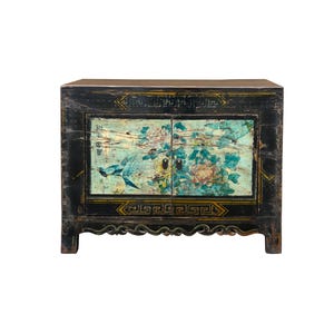 May include: A black antique cabinet with two doors featuring a painted design of birds and flowers. The cabinet has a carved base and gold accents.