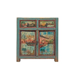 May include: A rectangular wooden cabinet with a distressed teal finish, featuring two top drawers and two lower doors. The front panels are decorated with hand-painted landscape scenes depicting buildings, bridges, and trees in muted tones.