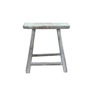 May include: A weathered, gray wooden stool with a rectangular seat and four angled legs. The stool has a rustic, distressed appearance, suggesting it is handmade or antique. The design is simple and functional, suitable for various uses.