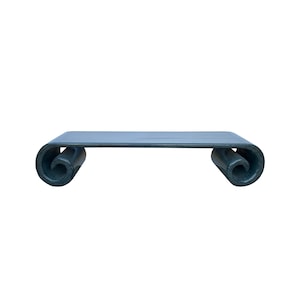 May include: A dark green, scroll-shaped coffee table with a flat top and rounded ends.
