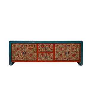 May include: A blue and red Chinese-style cabinet with intricate floral patterns on the doors and drawers. The cabinet has a rectangular shape and sits on four legs.