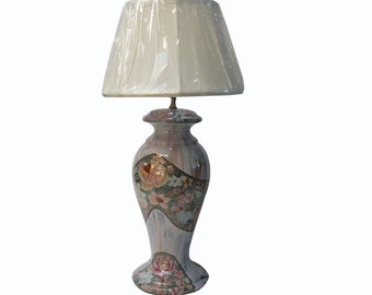 May include: A white ceramic table lamp with a floral design. The lamp has a white fabric shade and a floral pattern on the base.