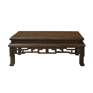 May include: A dark brown wooden table with intricate carvings on the legs and a simple rectangular top. The table is made of solid wood and has a traditional Chinese design.