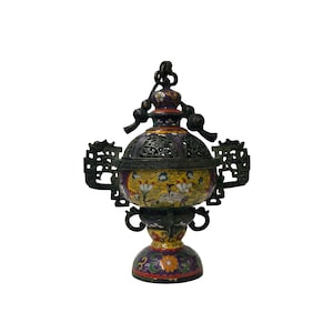 May include: An ornate, antique incense burner with a detailed floral and figure design. The burner features a yellow and purple body with intricate metalwork and a decorative handle. The base is adorned with colorful floral patterns.
