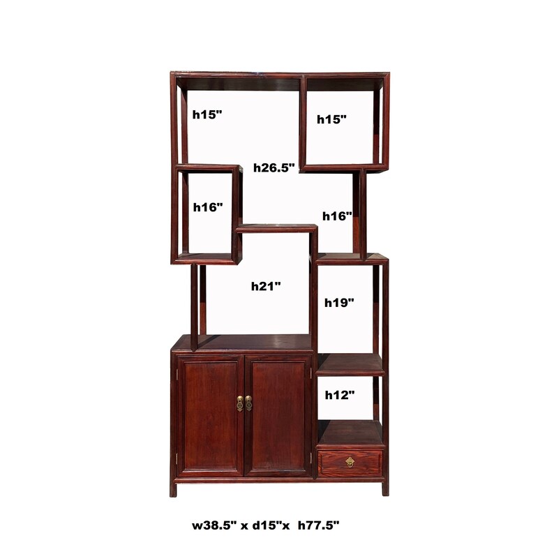 May include: A dark wood bookcase with a unique asymmetrical design. It features multiple shelves of varying sizes, including a cabinet with two doors and a drawer. The bookcase measures 38.5 inches wide, 15 inches deep, and 77.5 inches high.