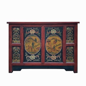 May include: A dark red wooden cabinet with two doors. The doors are painted with intricate floral designs and scenes of people and animals in a yellow, green, and blue palette.