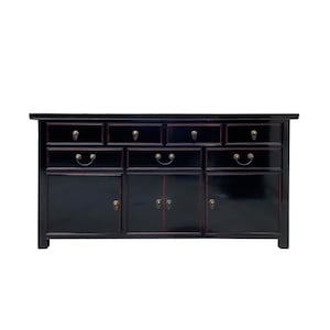 May include: Black lacquered sideboard with six drawers and three doors. The sideboard has brass hardware and a red interior.