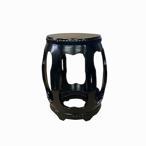 May include: Black wooden stool with a round top and an open, lattice-like design. The stool has a traditional Chinese style.