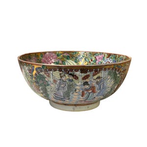 May include: A large, round, white porcelain bowl with a colourful floral and figural design. The bowl features a scene of people in traditional Chinese clothing, surrounded by flowers and trees. The bowl has a gold rim and a gold design on the exterior.