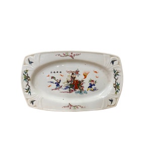 May include: A white oval ceramic serving dish with a raised rim and a floral design. The dish features a colorful scene of people and animals, with the text "江山如畫" in black.