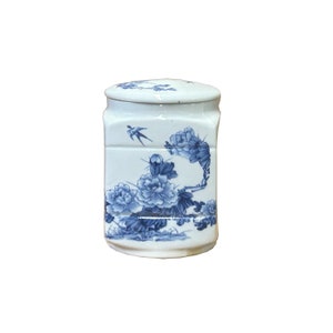 May include: A white ceramic jar with a blue and white floral design. The jar has a lid and is decorated with a bird and flowers.