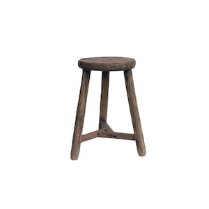May include: A rustic wooden stool with a round seat and three legs. The stool is made of dark brown wood and has a natural finish.