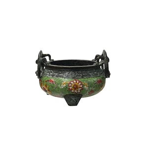 May include: An antique bronze incense burner with a green enamel floral design. The burner has two handles and three feet. The floral pattern includes red, yellow, and white flowers. The rim and handles are dark bronze.