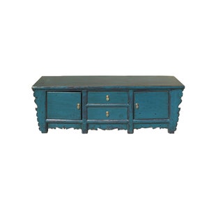 May include: A teal blue antique-style wooden cabinet with three drawers and two doors. The cabinet has ornate carvings and brass hardware.