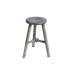 May include: A rustic wooden stool with a round seat and three legs. The stool is made of weathered wood and has a natural finish.