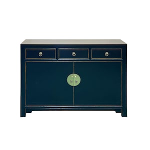 May include: A dark blue rectangular sideboard featuring three top drawers with small circular metal pulls and two lower cabinet doors with a central circular metal plate and latch. The edges of the drawers and doors are accented with thin gold lines.