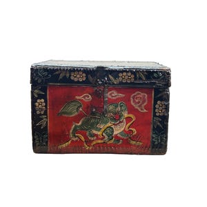 May include: A rectangular, antique wooden chest with a hinged lid. The chest is painted with a red background and features a green and yellow mythical creature design. The edges are black with floral and butterfly accents.