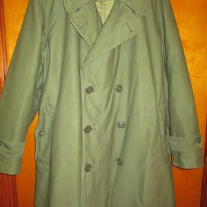 May include: A long, green, double-breasted coat with a large collar and button closures.