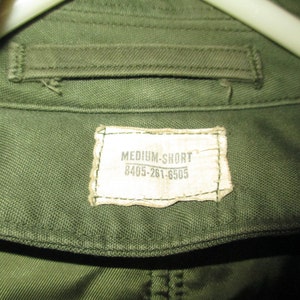 May include: A green cotton shirt with a white tag that reads "MEDIUM-SHORT 8405-261-6505".