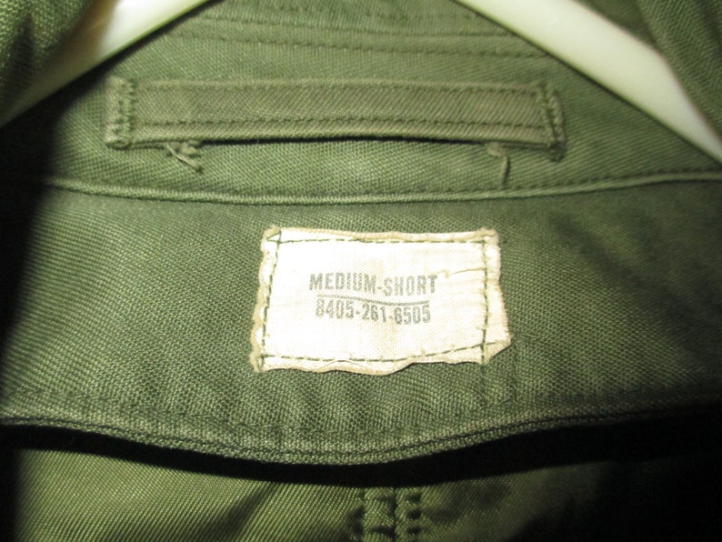 May include: A green cotton shirt with a white tag that reads "MEDIUM-SHORT 8405-261-6505".