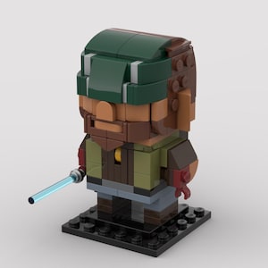 Peut inclure: Une figurine stylisée et cubique construite en briques de plastique. Le personnage porte un couvre-chef vert foncé, une barbe brune, un gilet vert olive et un pantalon gris. Une main tient une petite tige lumineuse bleue translucide.