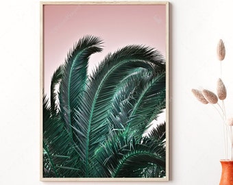 May include: A framed print featuring a close-up of vibrant green palm fronds against a soft pink sky. The artwork is displayed near a table with decorative vases and dried flowers, creating a serene, natural aesthetic.